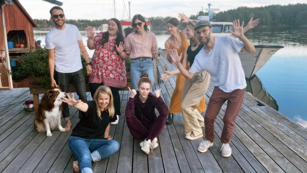 8 stycken personer på en brygga vänder sig glatt mot kameran.