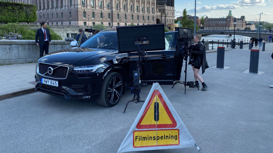 svart bil framför kungliga slotte och en skylt där det står filminspelning