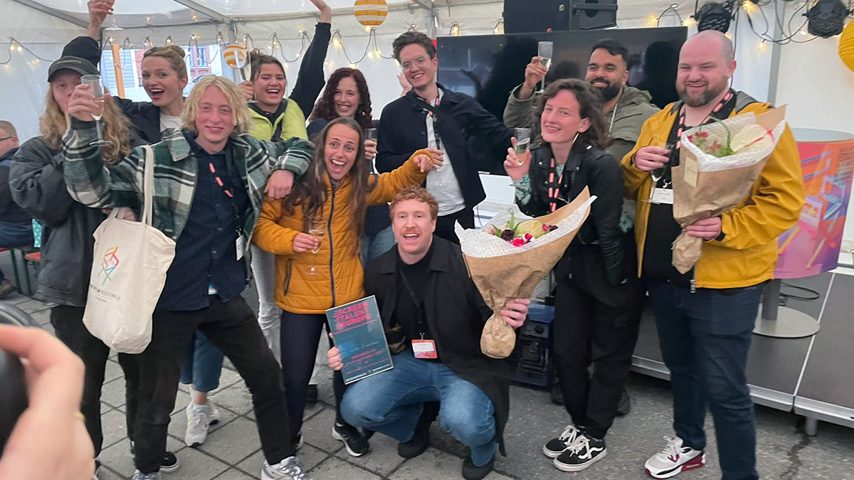 Ett gäng glada firande unga med blommor och champagneglas