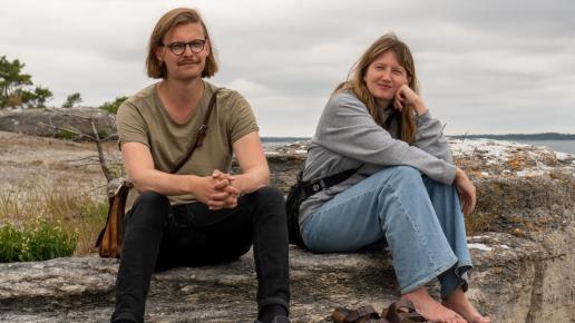 Man och kvinna sitter på en klippa vid stranden på Fårö