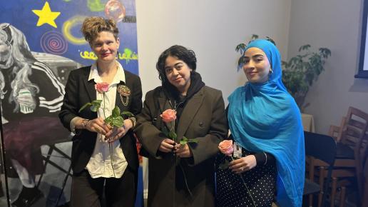 Tre kvinnor med varsin rosa ros i handen