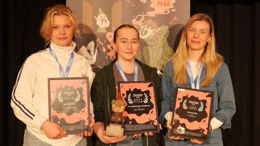tre kvinnor håller upp diplom