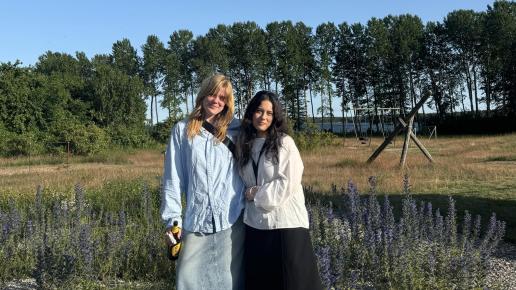 två kvinnor framför fårölandskap