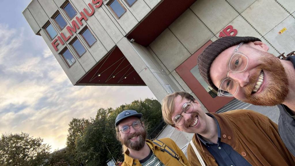 tre glada män framför filmhuset. i Stockholm