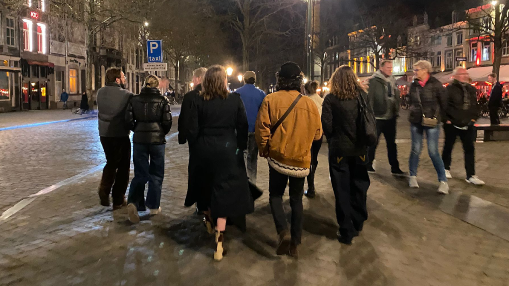 en grupp unga vuxna går på ett torg